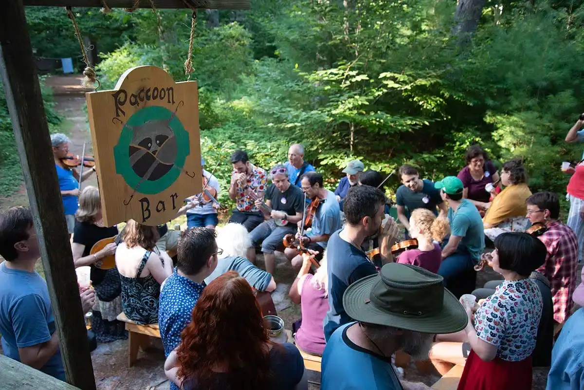 Musicians jamming under the Raccoon Bar sign