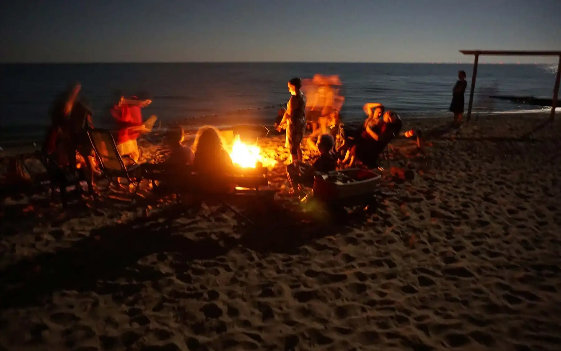 Campers gathered around a bonfire on the beach. Photo by Pat McGrath.