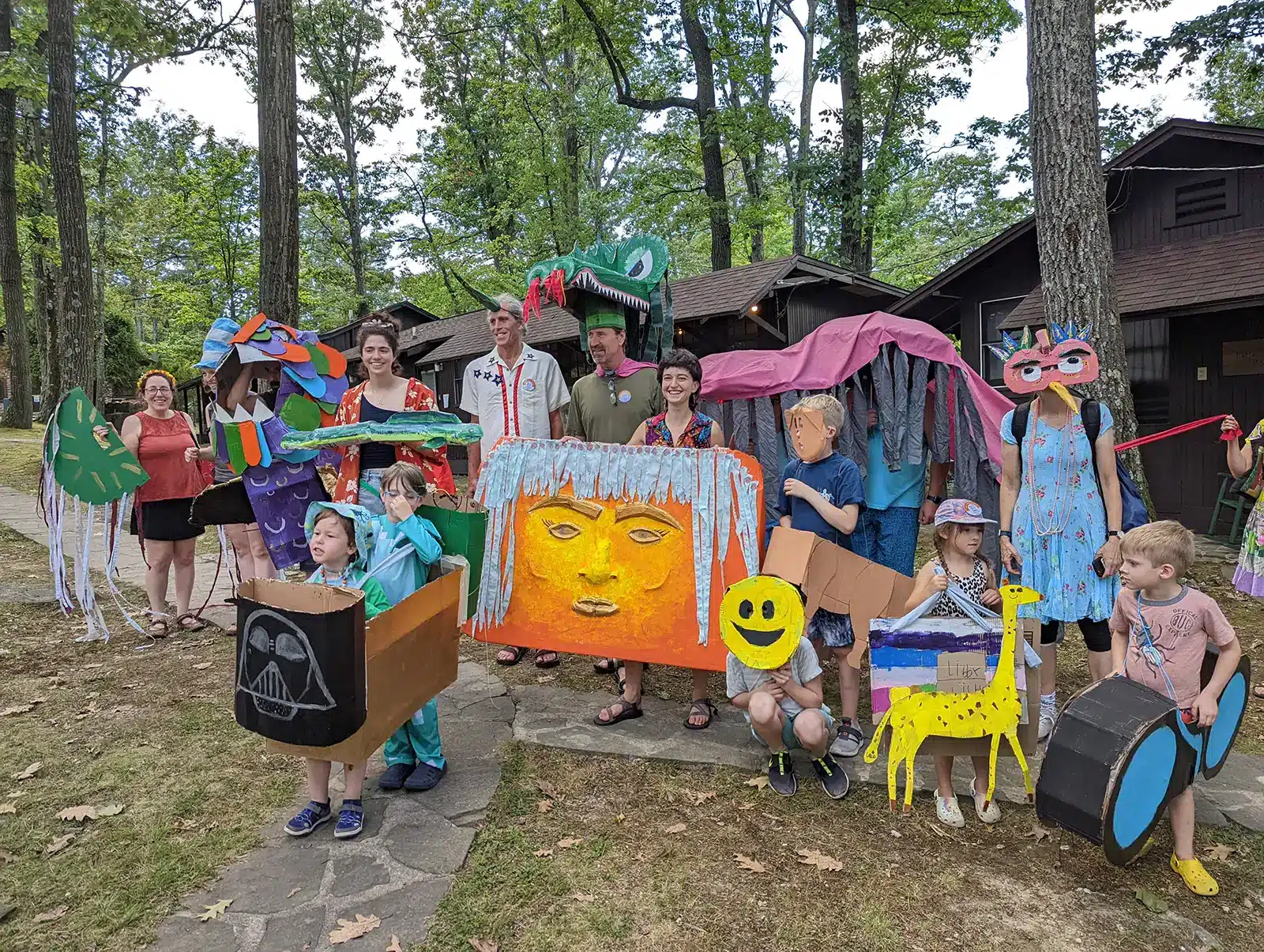 Campers of all ages with colorful papier-mache costumes
